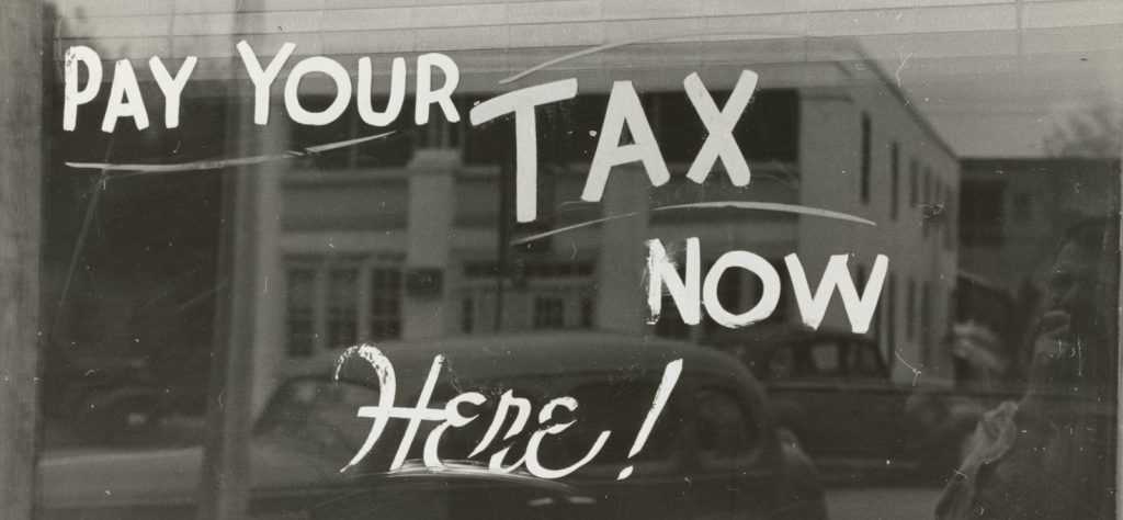 a sign that says pay your tax now here